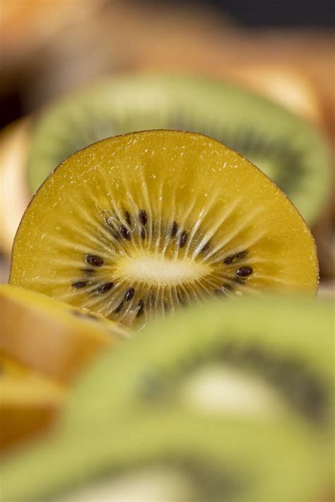 Green And Yellow Kiwi Fruit Cut Into Pieces Close Up Stock Photo