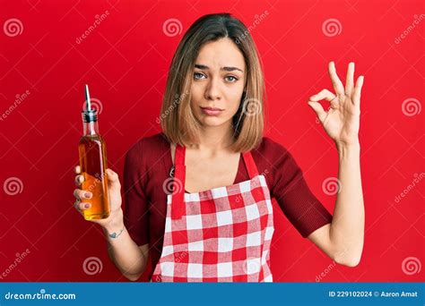 Young Caucasian Blonde Woman Wearing Cook Apron Holding Olive Oil Bottle Depressed And Worry For