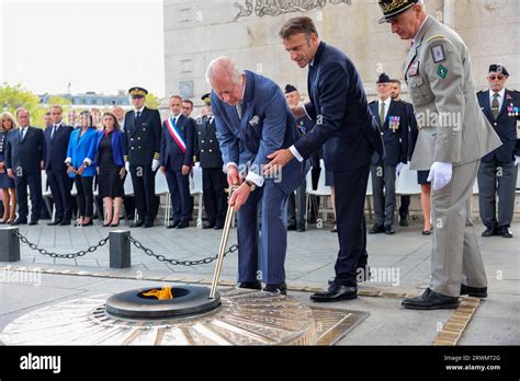 King Charles III performs the rekindling of the eternal flame using the