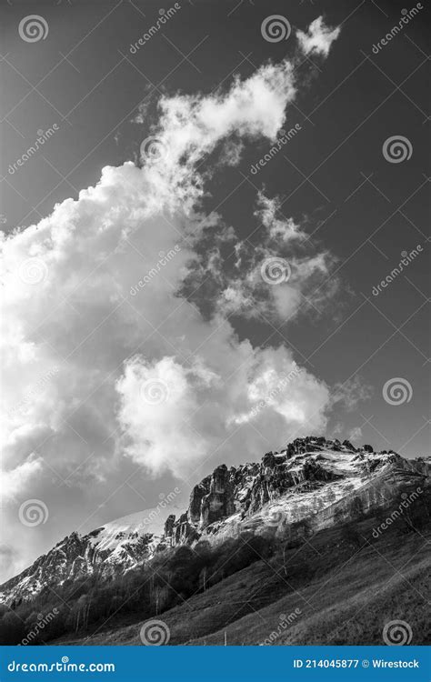 Grayscale Shot Of Rocky Mountains Partially Covered By Snow On The