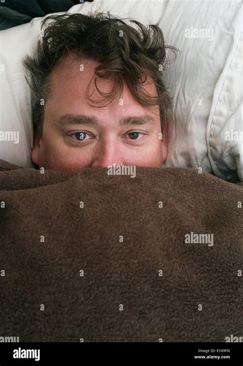 A Sleepy Man Looking At The Camera Stock Photo Alamy