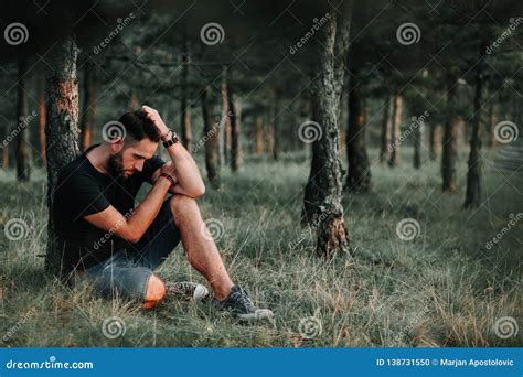 Young Depressed Man Sitting Alone In The Woods Stock Photo Image Of