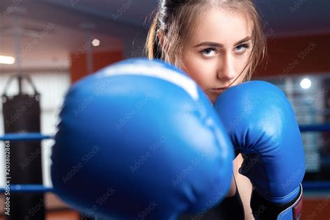 woman with black boxing wraps and boxing gloves on hands boxing in ring active girl fight stock
