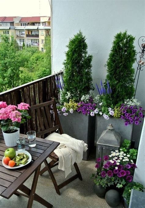 A Balcony With Potted Plants And Flowers On The Table Along With A