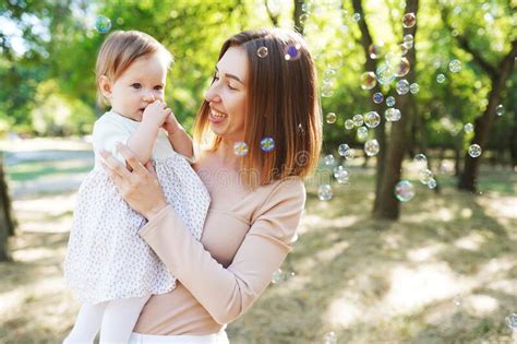 happy mother and daughter blowing bubbles in the park stock image image of daughter beautiful