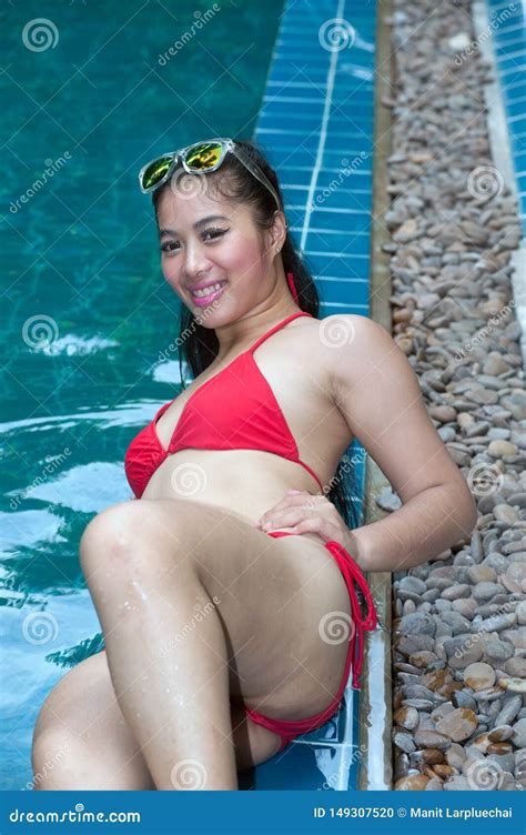Hübsche Asiatin Den Roten Bikini Liegt am Swimmingpoolrand Mit Sonnenbrille Trägt Stockfoto