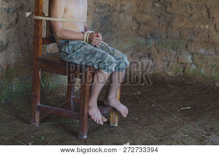 Victim Boy With Hands Tied Up With Rope In Emotional Stress And Pain