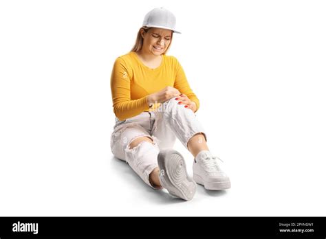 Young Female Sitting On The Floor And Holding Her Painful Knee Isolated