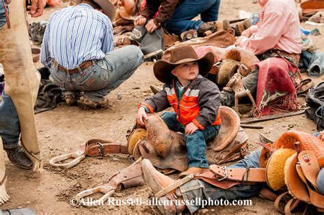 Young Cowboy Playing Behind Chutes With Saddle Bronc