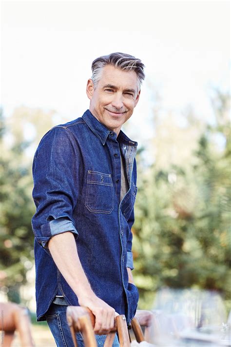 Mature Man Setting The Table For A Farm To Table Dinner Party