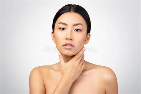 shirtless asian lady delicately touching her neck over gray background stock image image of