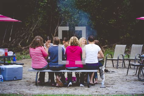 People Sitting At A Picnic Table At A Campsite — Photo — Lightstock