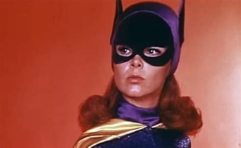 A Woman Wearing A Batman Mask And Cape With Her Hands On Her Hips In