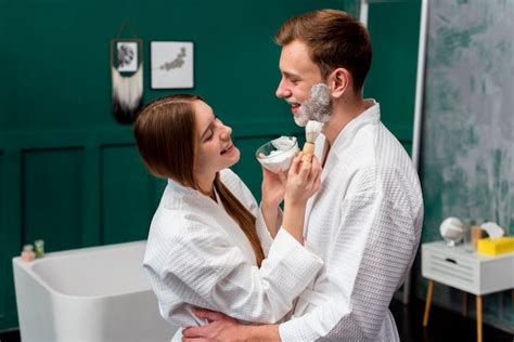 Free Photo Embraced Couple In Bathrobes Applying Shaving Foam