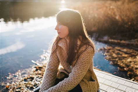 Woman Sitting On Dock Near Lake By Stocksy Contributor Joe St Pierre Stocksy