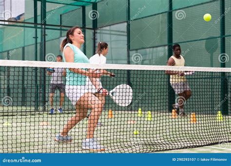 Sporty Woman And Other Athletes Training On Tennis Court Stock Image