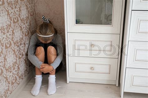Sad Little Girl Sitting In The Corner Stock Image Colourbox