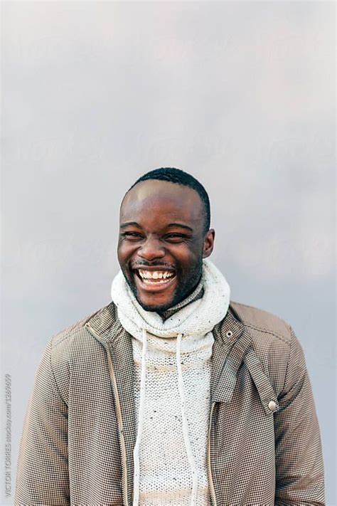 African American Man Smiling Over A White Wall By Victor Torres For