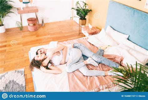 Happy Young Couple On Bed In Bedroom Have Fun Romantic Time Together Concept Stock Image