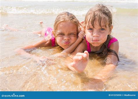 Deux Filles Se Situant En Eau Peu Profonde Et Amusement Feignant Des