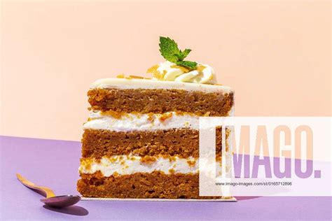 slice of tasty sweet carrot sponge cake with cream decorated with mint leaf served on plate with