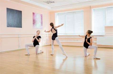 Ballet Teacher Helping Young Girls To Dance En Pointe Stock Photo