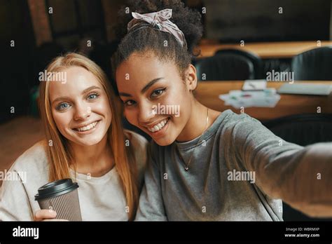 Portrait Of Two Multiracial Young Women Smiling While Taking Selfie