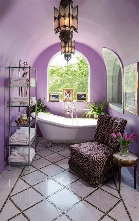 Bathroom features blue dual washstand topped in gray marble with sinks that boast satin nickel faucets, under three white paneled mirrors flanked by nickel and white sconces. Get Inspired With Purple Bathrooms