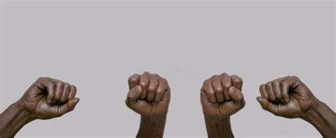 Black African American Human Hands With Raised Fists In The Air On A