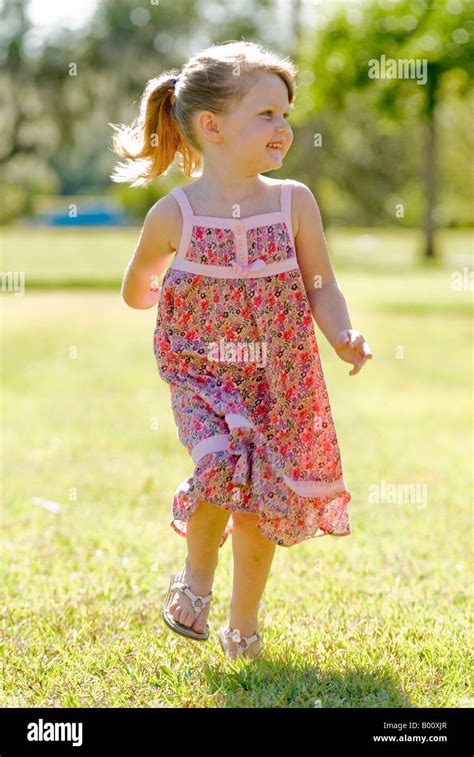 Little 4 Year Old Girl Running In The Park In Sun Dress With Stock