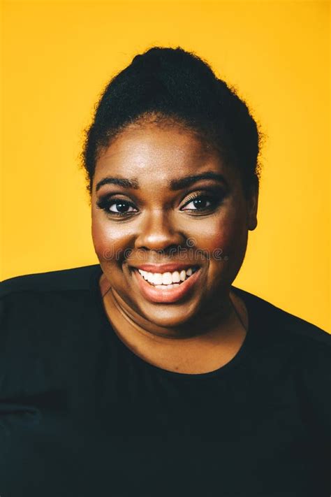 Close Up Portrait Of A Beautiful Black Woman Smiling With Crossed Arms On Yellow Background