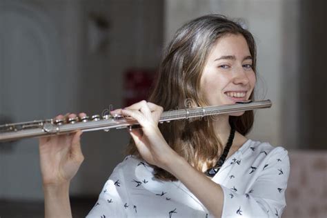 A Beautiful Woman Posing While Playing On A Flute Stock Photo Image