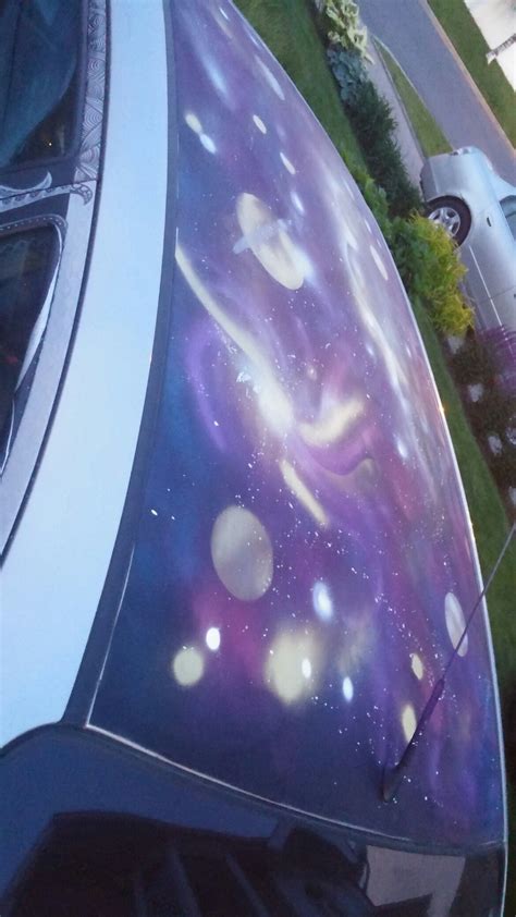 Galaxy Painting With Spray Painting Cans On The Top Of The Car