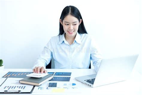 Asian Female Accountant Sits At Their Desks And Calculates Financial