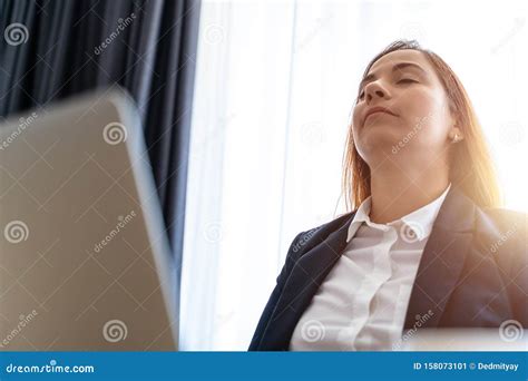 Young Business Woman Relaxes Leaning Back Her Head And Closing Her Eyes