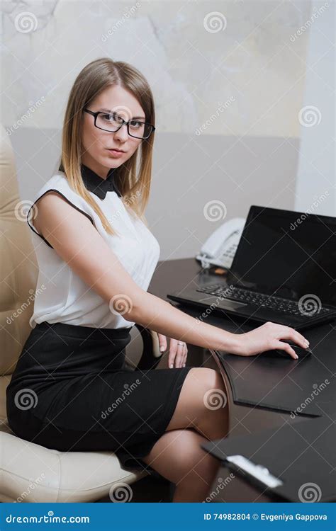 Сексуальная бизнес леди сидя на столе в офисе Стоковое Фото