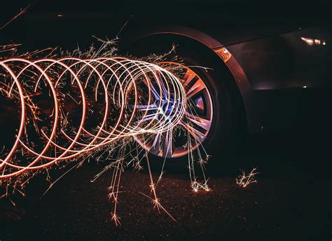 A Long Exposure Photo Of A Sparkler On Fire Coming Off Of A Car Tire