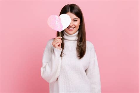 Romantic Brunette Female Standing Covering Eye With Rosy Heart On Stick