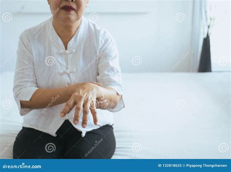 Elderly Woman Suffering With Parkinson`s Disease Symptoms On Hand Stock