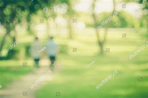 Blur People Walking In Nature Green Park With Sun Light Copy Space