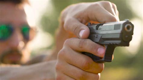 Young man is shooting from a gun, close up Stock Video Footage 