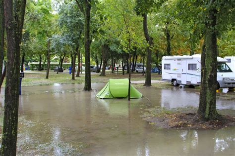 A Tent Is In The Middle Of A Flooded Area With Trees And Rvs Behind It