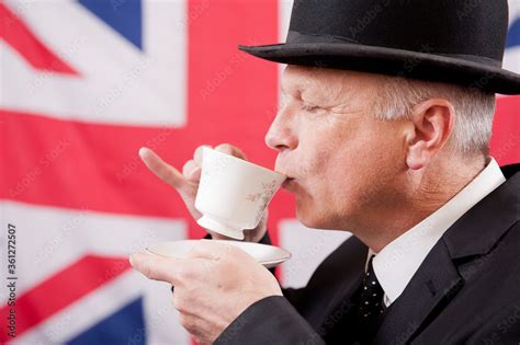 Englishman Drinking Afternoon Tea From A Cup And Saucer Hes Wearing A