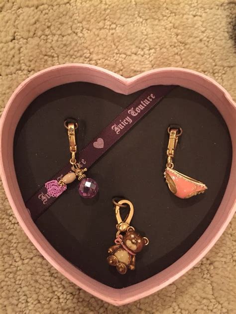 A Pink Heart Shaped Box With Keychains And Charms In It On The Floor