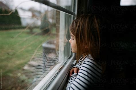 Little Girl Looks Out Window By Stocksy Contributor Maria Manco