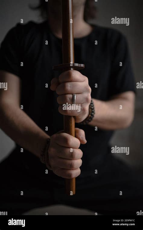 Closeup Image Of Manâ€™s Hands Holding Wooden Sword In Front Of Himself