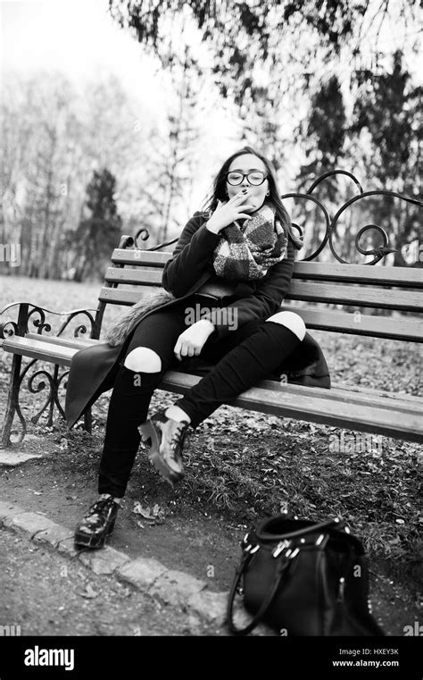 Young Girl Smoking Cigarette Outdoors Sitting On Bench Concept Of