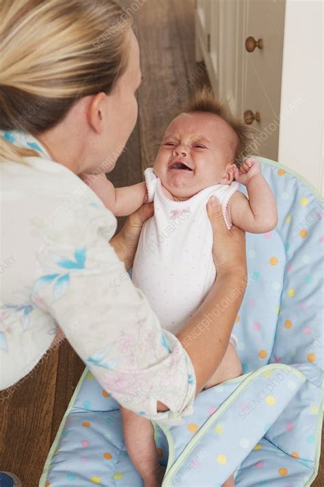 Woman Picking Up A Crying Baby Girl Form A Seat Stock Image C052