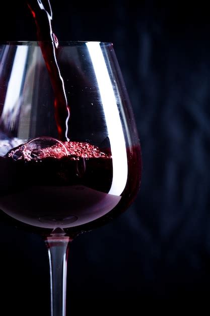 Premium Photo Pouring Red Wine Into The Glass