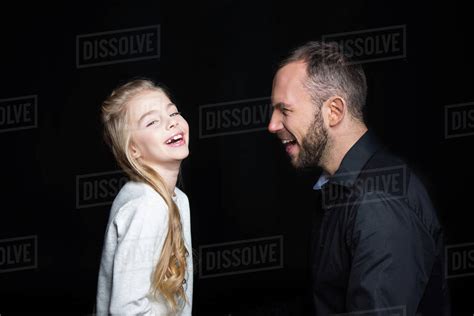 Smiling Father And Daughter Laughing Together Isolated On Black Stock